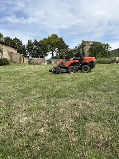 Tracteur-tondeuse autoporté en action sur une pelouse de la Drôme